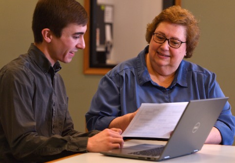 Teacher and student with laptop.