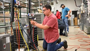 A student in air conditioning class testing out the heating and cooling systems