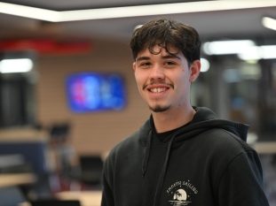 A student smiling for the camera in the cafeteria